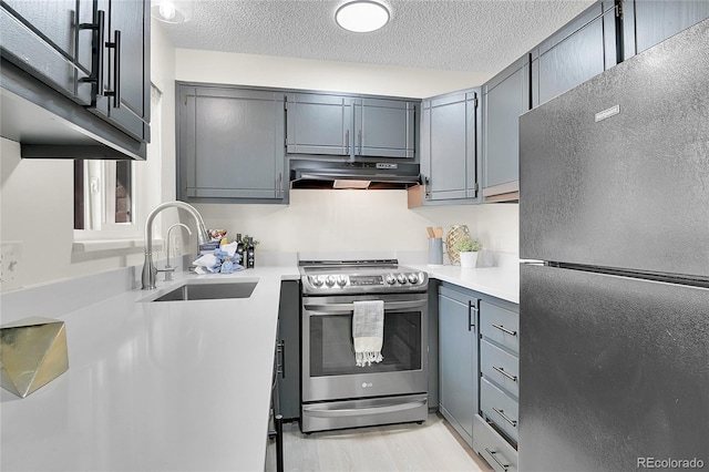 kitchen with stainless steel appliances, a textured ceiling, sink, and gray cabinetry