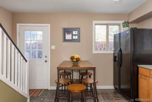 kitchen featuring dark tile patterned flooring and black fridge