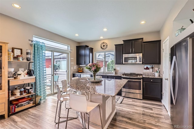5153 Andes Way, Denver, CO 80249 - kitchen with stainless steel appliances, plenty of natural light, light stone countertops, light wood-style floors, and recessed lighting