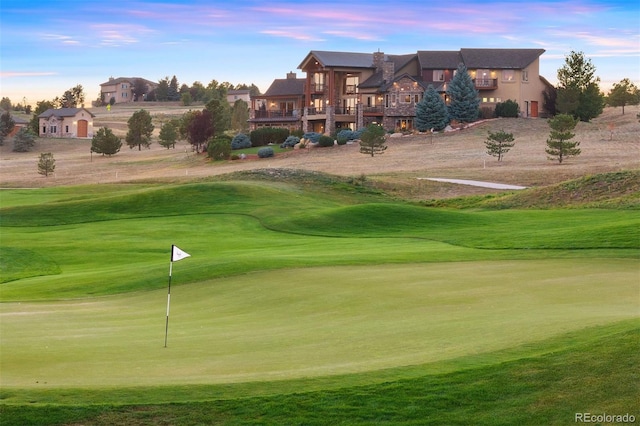 view of home's community with a lawn, a deck, and golf course view