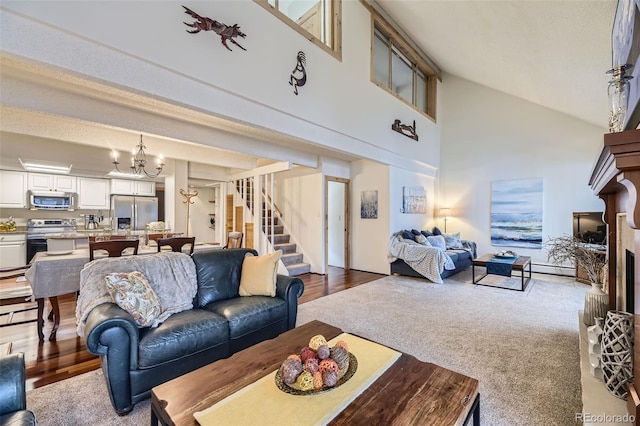 living room with high vaulted ceiling, an inviting chandelier, and hardwood / wood-style floors