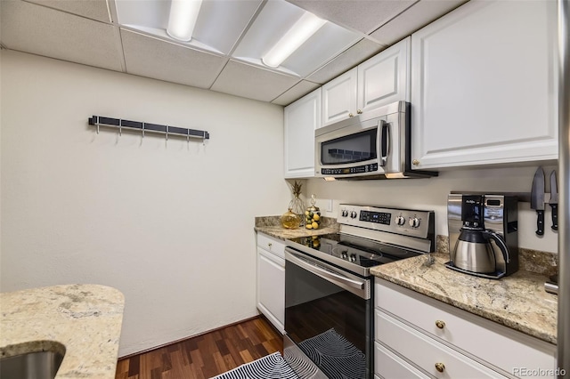 kitchen featuring dark wood-type flooring, a paneled ceiling, appliances with stainless steel finishes, and white cabinets