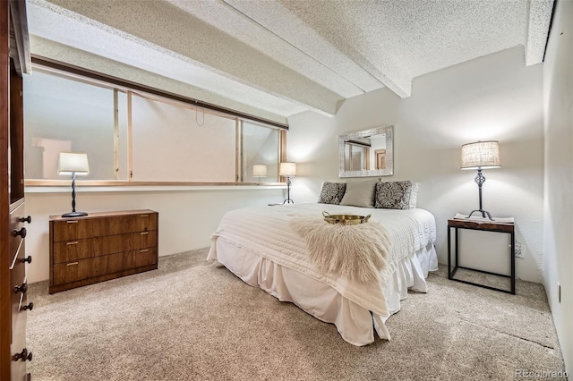 carpeted bedroom with beam ceiling and a textured ceiling