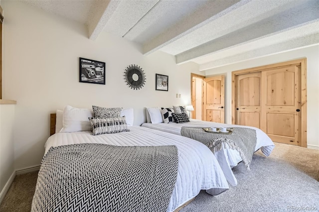 bedroom featuring beamed ceiling, a textured ceiling, and carpet floors