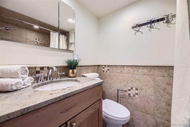 bathroom featuring toilet, vanity, tile walls, and a shower with shower curtain