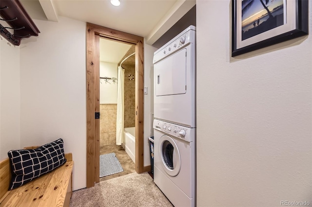 clothes washing area featuring stacked washer / drying machine and carpet floors