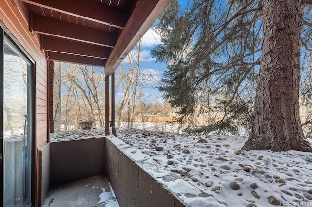 view of snow covered back of property