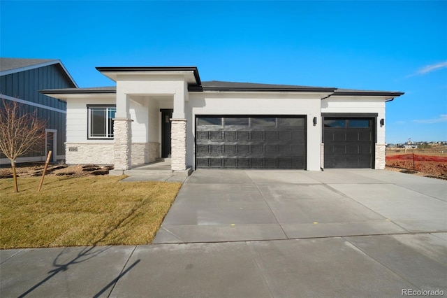 prairie-style house with a garage and a front lawn