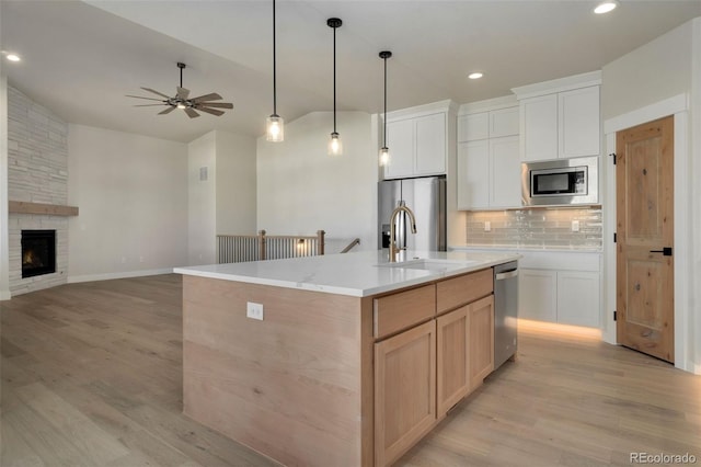 kitchen featuring a spacious island, stainless steel appliances, decorative backsplash, and white cabinets