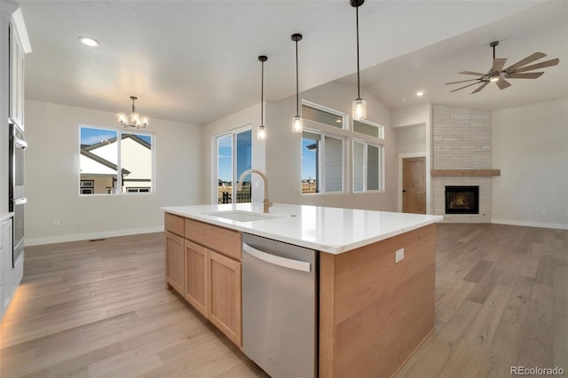 kitchen with pendant lighting, an island with sink, lofted ceiling, sink, and stainless steel appliances