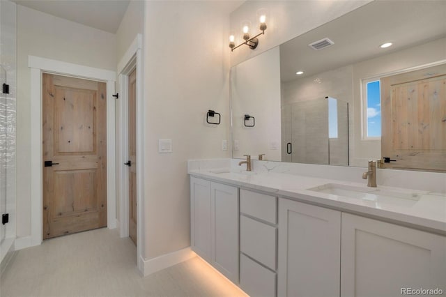 bathroom with a shower with door and vanity