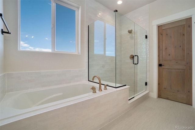 bathroom featuring shower with separate bathtub