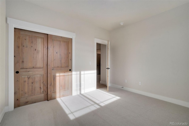 unfurnished bedroom with a closet and light carpet