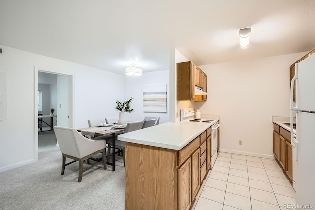 13093 W Cedar Dr Unit 121, Lakewood, CO 80228 - kitchen with white appliances, under cabinet range hood, brown cabinets, and light countertops