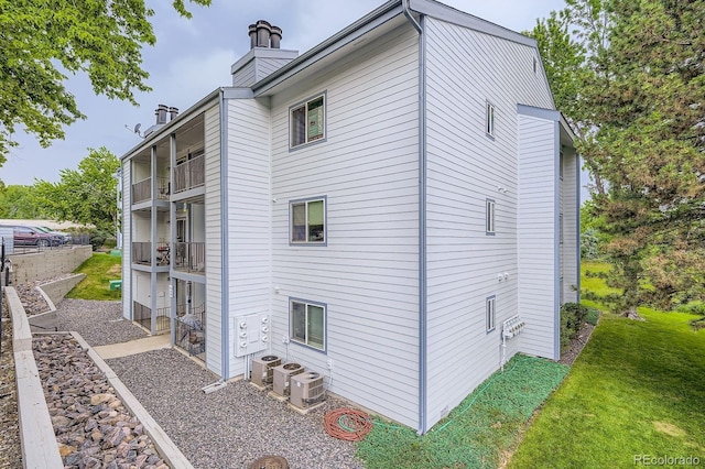 13093 W Cedar Dr Unit 121, Lakewood, CO 80228 - view of side of property featuring a chimney and a lawn