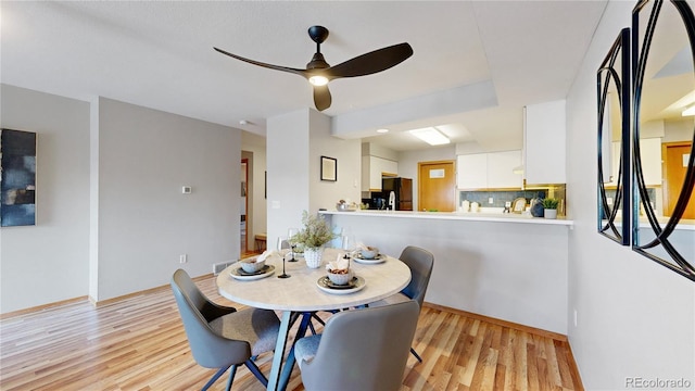 dining area with ceiling fan and light hardwood / wood-style flooring