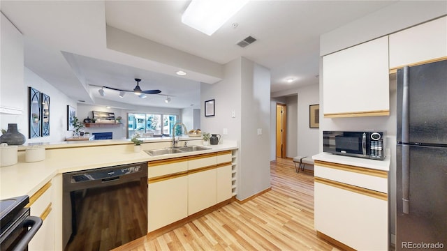 kitchen with sink, white cabinetry, ceiling fan, light hardwood / wood-style floors, and black appliances