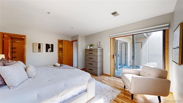 bedroom with light wood-type flooring and access to outside