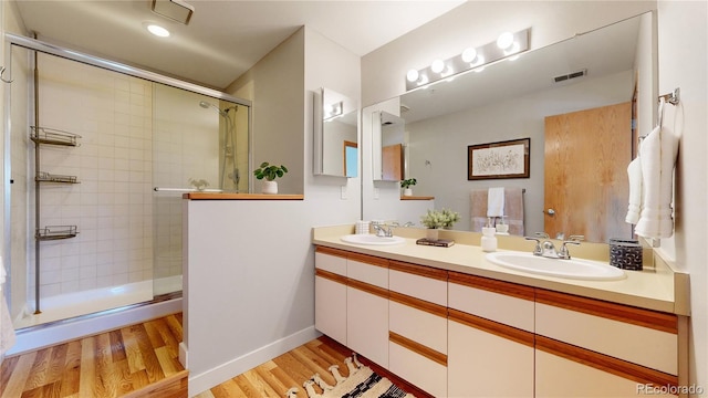 bathroom featuring hardwood / wood-style flooring, vanity, and a shower with door