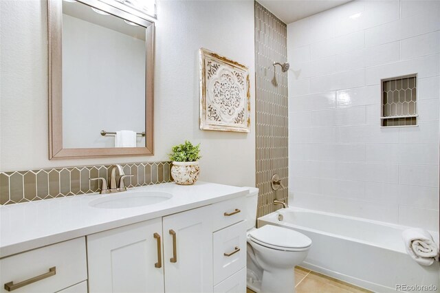 full bathroom featuring tile patterned flooring, vanity, toilet, and tiled shower / bath