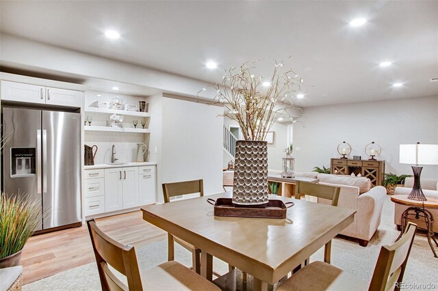 dining space with sink and light hardwood / wood-style floors