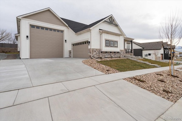 1361 Art Dr, Berthoud, CO 80513 - view of front of home with stone siding, concrete driveway, a garage, board and batten siding, and a front lawn
