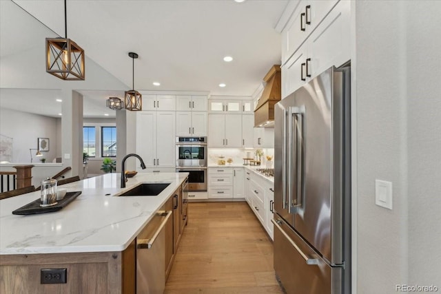 1361 Art Dr, Berthoud, CO 80513 - kitchen with appliances with stainless steel finishes, a sink, light wood-type flooring, hanging light fixtures, and white cabinetry