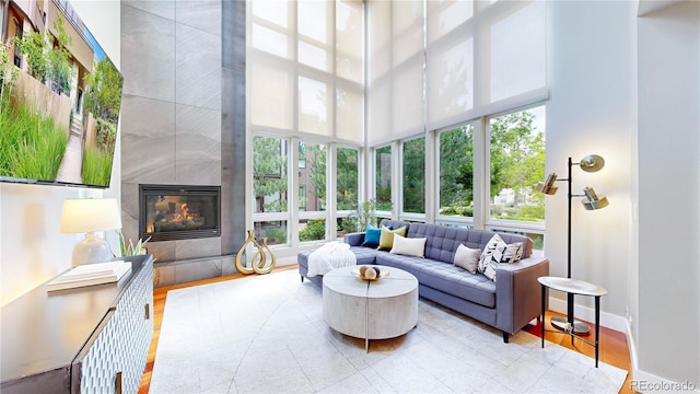 8041 E 29th Ave, Denver, CO 80238 - living area featuring a tile fireplace, a high ceiling, and wood finished floors