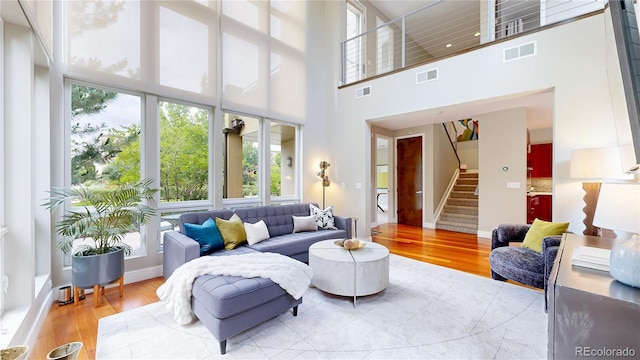 8041 E 29th Ave, Denver, CO 80238 - living area with wood finished floors, a high ceiling, and stairs