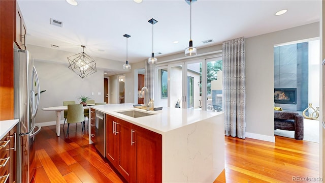 8041 E 29th Ave, Denver, CO 80238 - kitchen with stainless steel appliances, light wood-style flooring, light countertops, recessed lighting, and hanging light fixtures