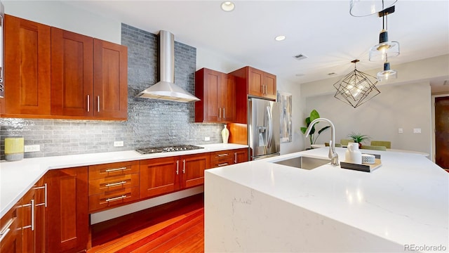 8041 E 29th Ave, Denver, CO 80238 - kitchen featuring appliances with stainless steel finishes, wall chimney range hood, decorative backsplash, hanging light fixtures, and dark wood finished floors