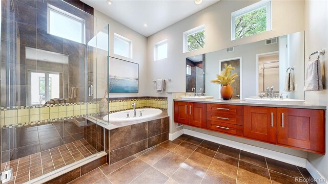 8041 E 29th Ave, Denver, CO 80238 - full bathroom featuring double vanity, a bath, a shower stall, tile patterned flooring, and a towering ceiling