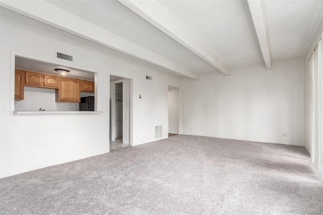9725 E Harvard Ave Unit 317, Denver, CO 80231 - unfurnished living room with carpet floors and beamed ceiling