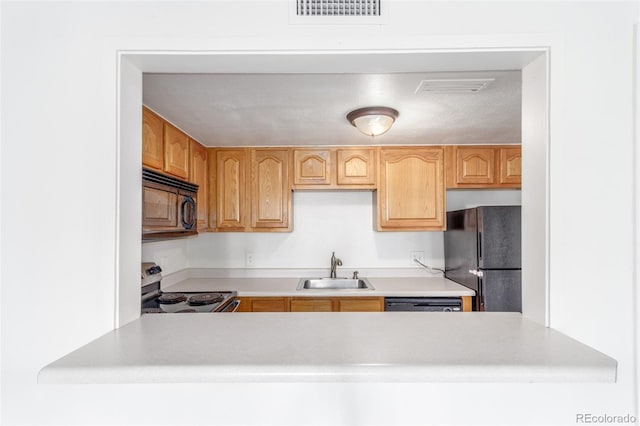 9725 E Harvard Ave Unit 317, Denver, CO 80231 - kitchen with black appliances, a sink, light countertops, and a peninsula