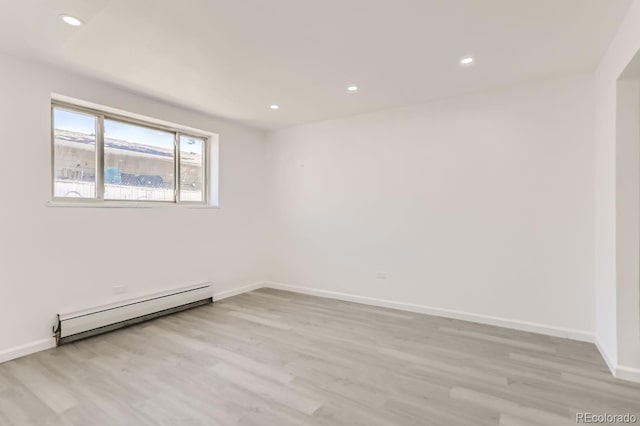 empty room with light hardwood / wood-style flooring and a baseboard radiator