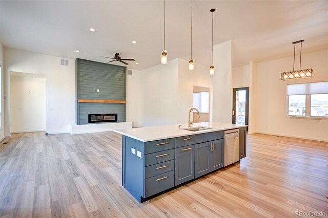 kitchen featuring visible vents, dishwasher, open floor plan, a fireplace, and a sink