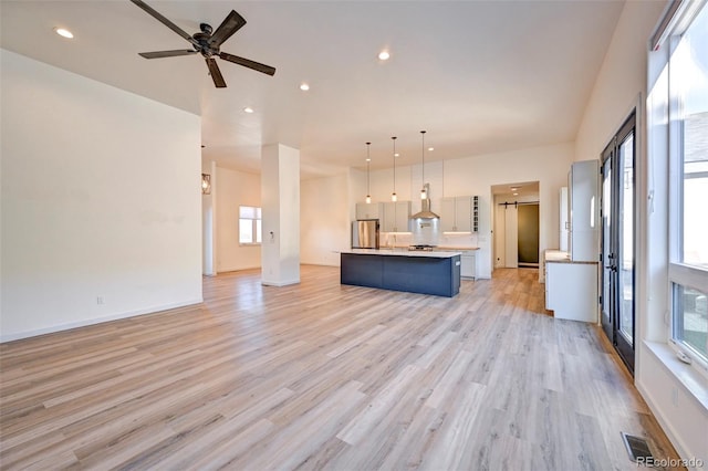 unfurnished living room with recessed lighting, a ceiling fan, baseboards, visible vents, and light wood-style floors