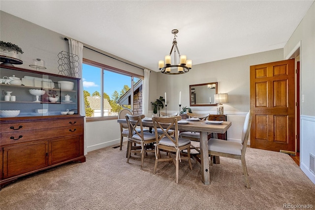 dining space featuring a notable chandelier and light colored carpet