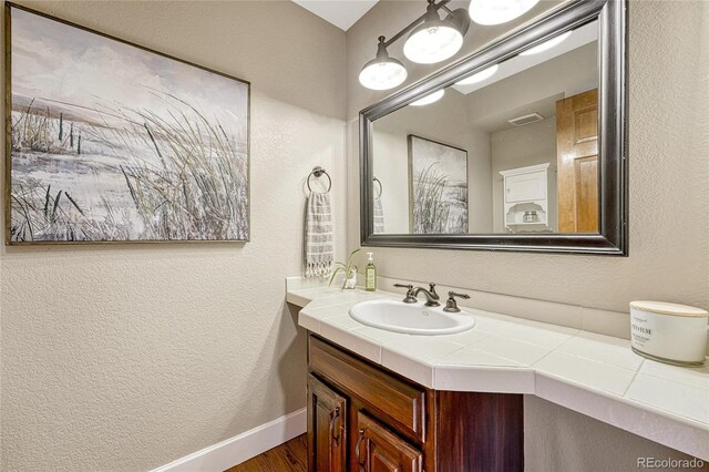 bathroom with hardwood / wood-style flooring and vanity