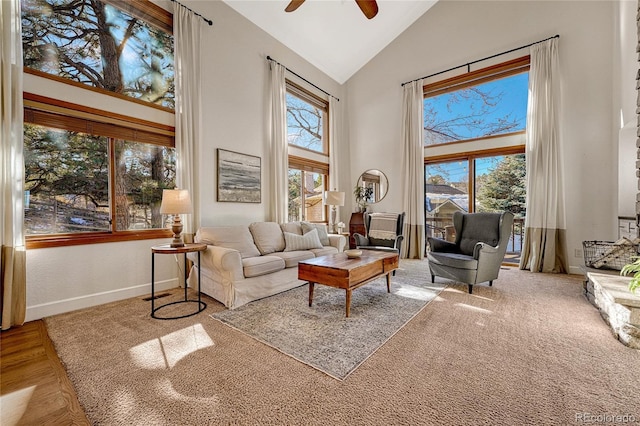 living area featuring ceiling fan and high vaulted ceiling