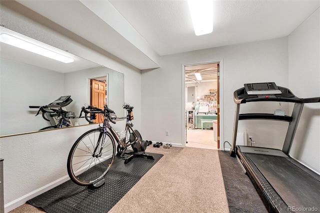 workout room featuring carpet floors and a textured ceiling