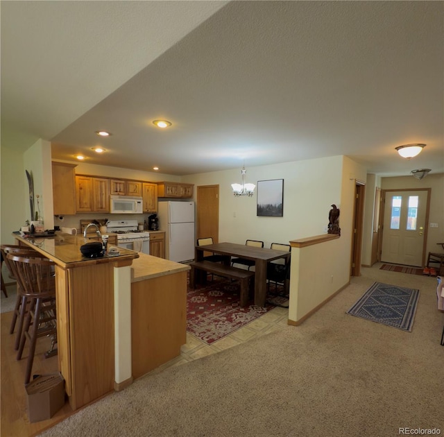 1436 H St Unit B, Salida, CO 81201 - kitchen featuring white appliances, a chandelier, a peninsula, light countertops, and brown cabinets
