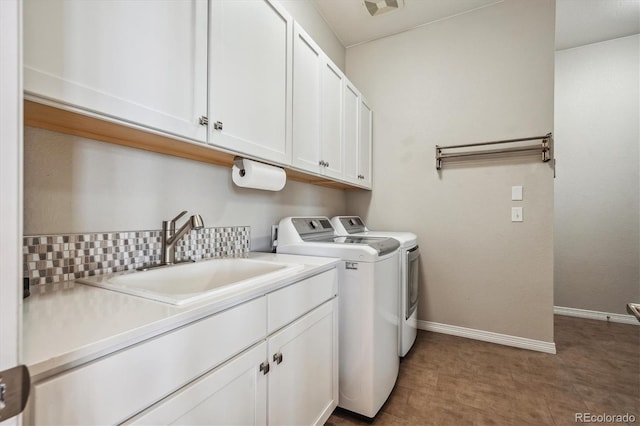 laundry area featuring independent washer and dryer, cabinets, and sink