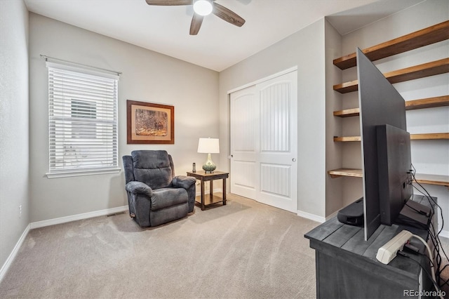 living area with ceiling fan and carpet flooring