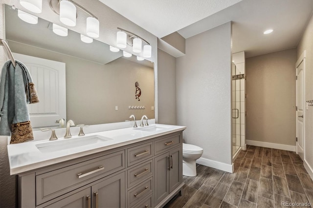 bathroom with vanity, toilet, an enclosed shower, and hardwood / wood-style floors