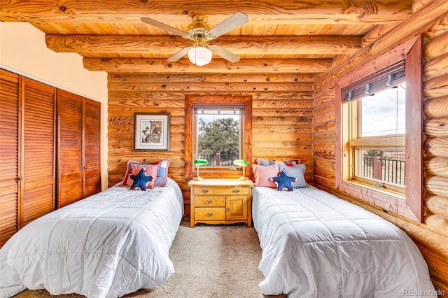 1528 Silverheels Rd, Fairplay, CO 80440 - bedroom featuring wood ceiling with exposed beams, log walls, light colored carpet, and a closet