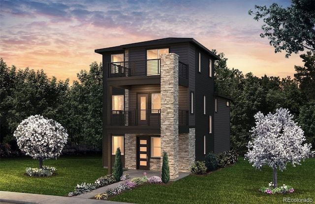 contemporary home featuring a balcony, stone siding, and a front yard