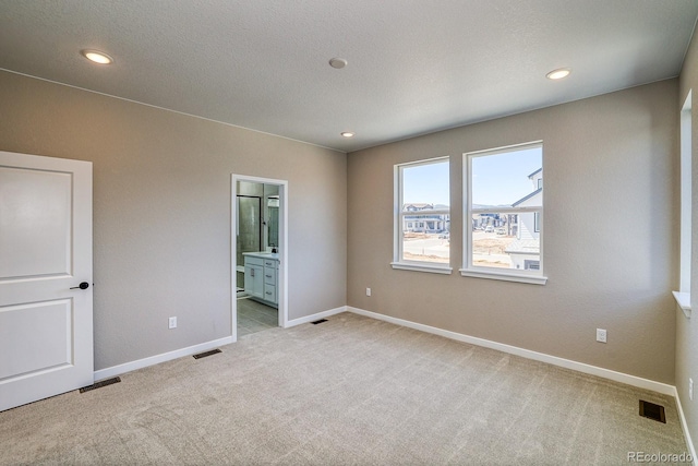 unfurnished bedroom featuring baseboards, visible vents, and light colored carpet