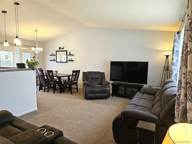 living room with lofted ceiling, a notable chandelier, carpet floors, and baseboards