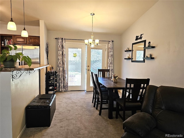 dining room featuring vaulted ceiling, an inviting chandelier, and carpet